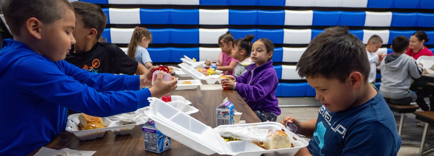 Students enjoying their lunch and talking with each other.